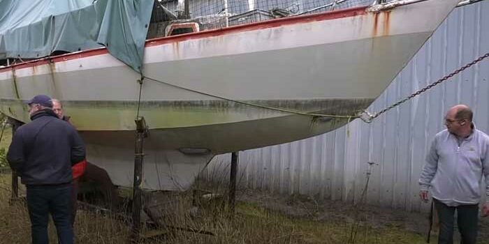 schrottboote Drei Männer begutachten ein Schrottboot